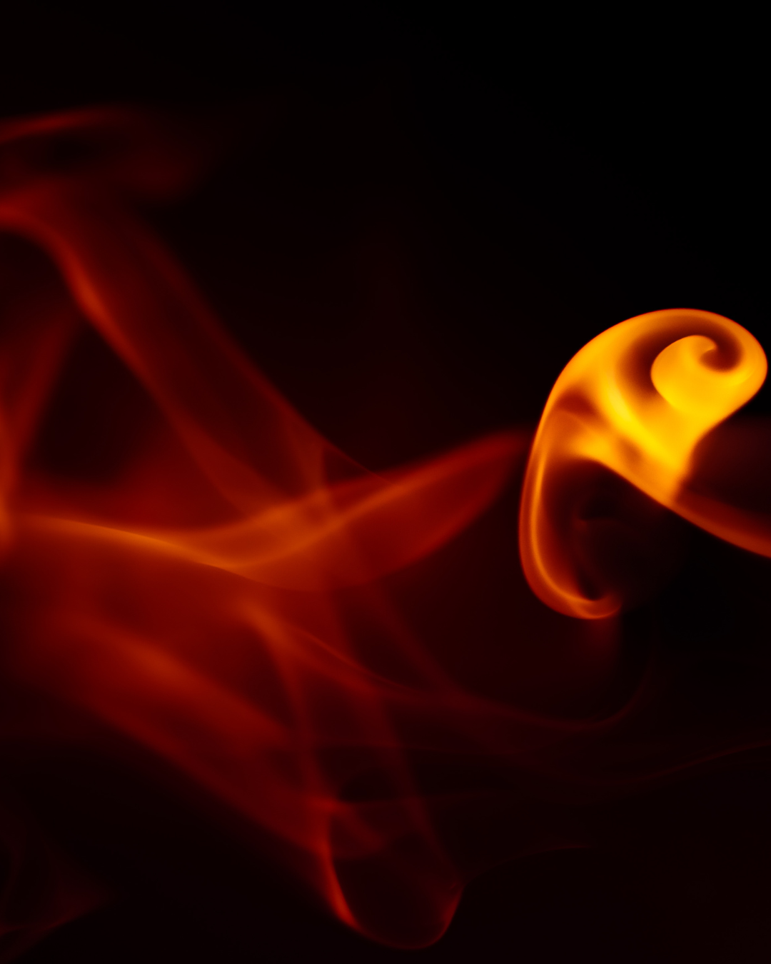 Abstract image of red-orange smoke trails fading into darkness, evoking the afterglow of a flame — used to illustrate a reflection on Autistic burnout and monotropism.