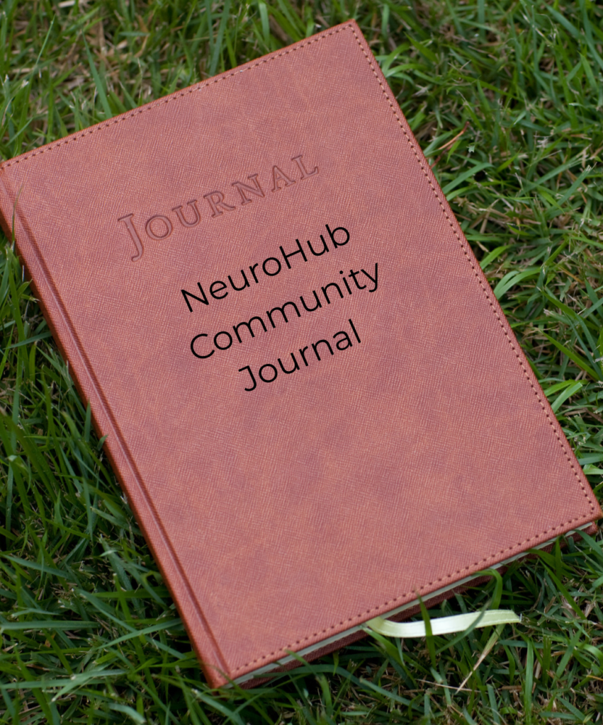 A rust-brown leather-textured notebook lies at an angle on fresh green grass. Its cover has the word Journal embossed in capital letters, with stitched edges around the border. Across the middle, black text reads NeuroHub Community Journal. A pale green ribbon bookmark peeks out from between the cream pages at the bottom edge.